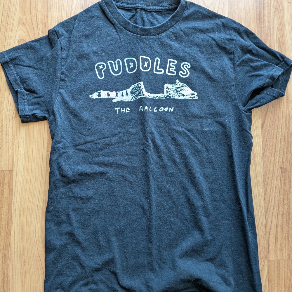 Black t-shirt featuring Puddles The Racoon Roadkill Design.